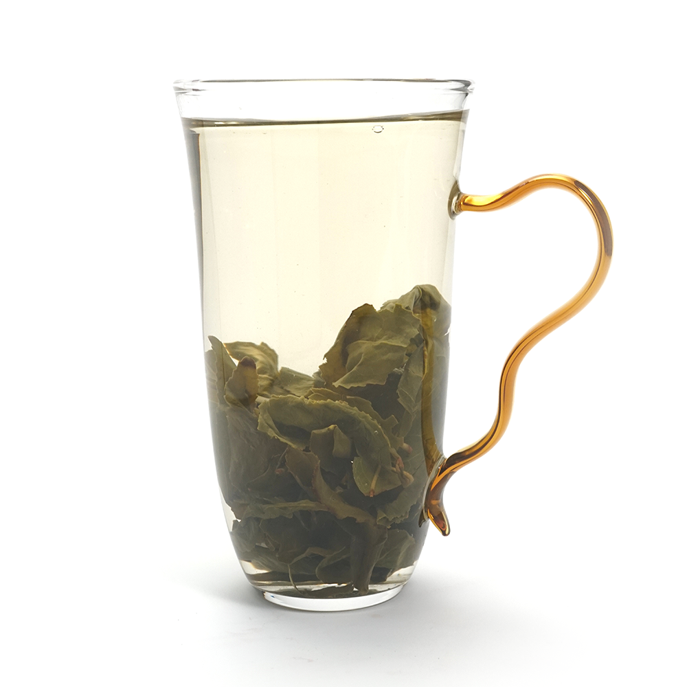 Fresh brewed Jin Gui oolong tea liquor in glass cup