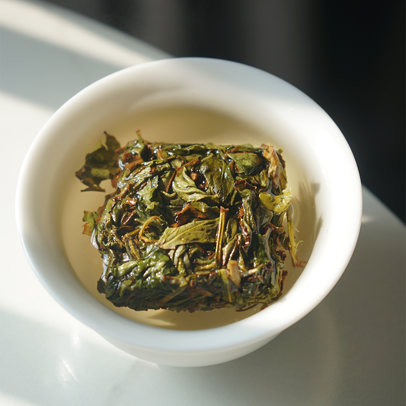 Green infused leaves of hand pressed oolong tea cake Zhangping Shui Xian
