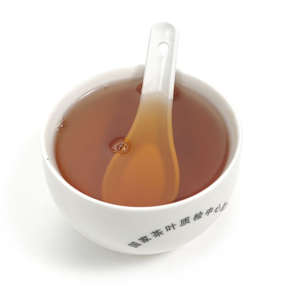 Vibrant amber tea soup of Fruity Dianhong (Black Beauty) in a glass cup for Gongfu brewing.