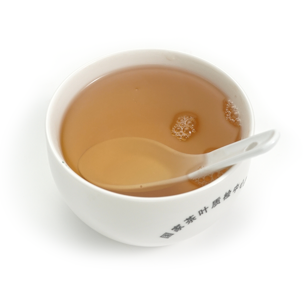Clear amber-gold liquor of the 2012 Fengpai Mellow Aged Raw Pu’er Tea after 14 years of aging.