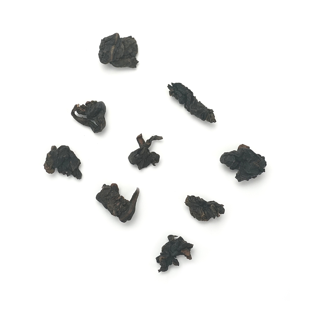 Traditional roasted oolong tea dry leaves with dark glossy appearance