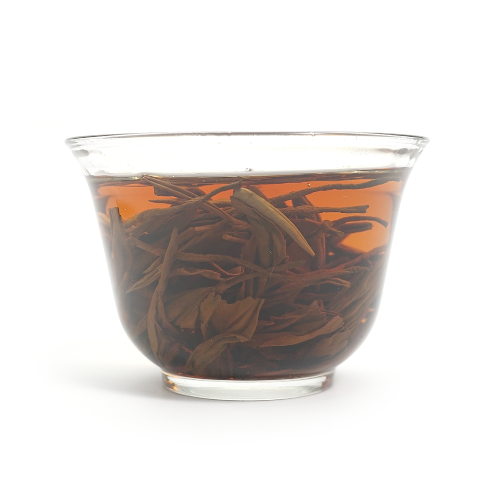 Premium Da Xue Shan Black Tea infusion displaying a rich, full-bodied golden-red color.