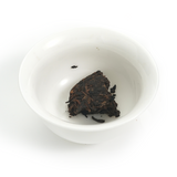 Decade-aged Shu Puerh tea cake from 2016 (200g) with tightly compressed and uniform tea leaves.