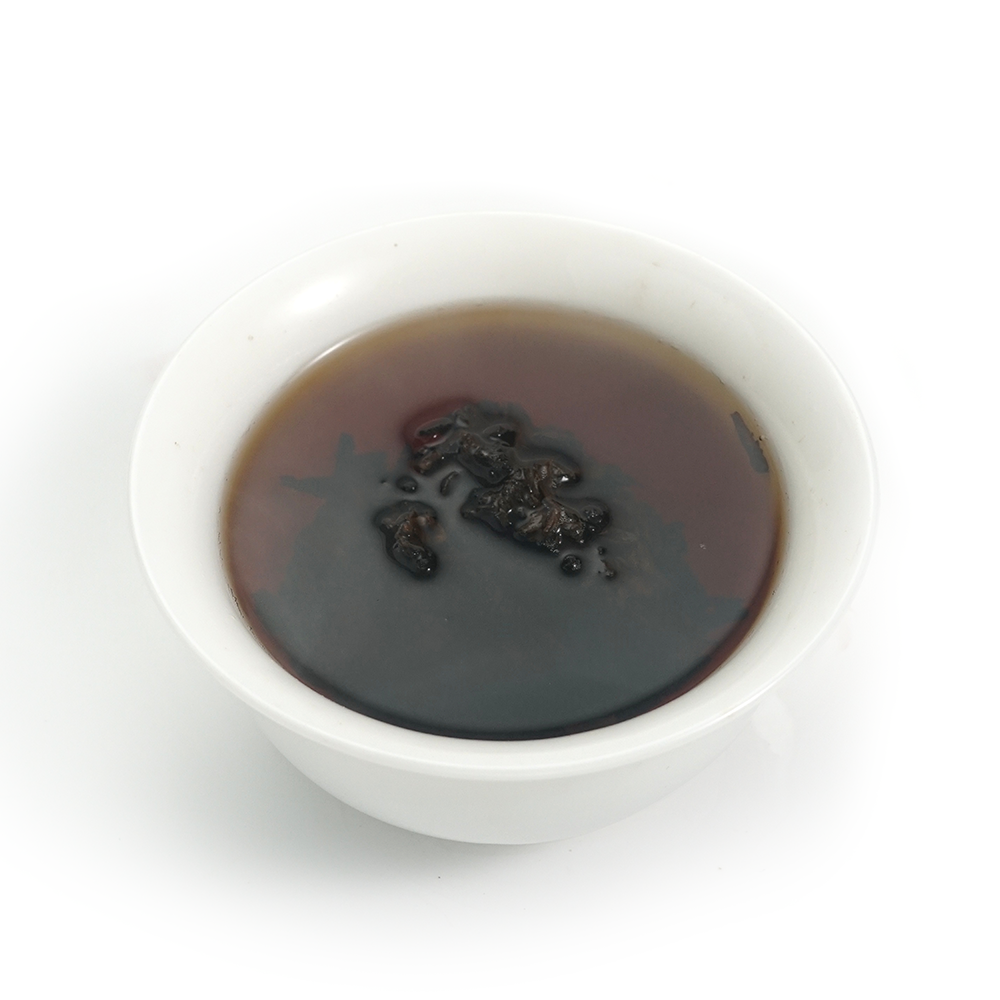 Deep burgundy-red tea liquor of the 2016 Decade-Aged Thick Ripe Pu’er Tea after 10 years of aging.