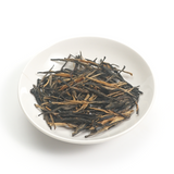 Tightly twisted dark brown leaves of Da Xue Shan Black Tea with a natural honey fragrance.